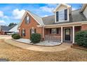 Close-up of a well-maintained brick home with a charming front porch, manicured shrubs, and meticulous landscaping at 115 Stewart Hollow Ln, Covington, GA 30016