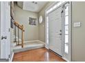 Bright foyer featuring hardwood floors, a staircase, and a white front door with sidelights at 208 Clifton Ln, Peachtree City, GA 30269