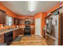 Modern kitchen with stainless steel appliances, granite countertops, and dark wood cabinets at 6142 Heisler St, Rex, GA 30273