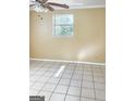 Bright bedroom featuring neutral walls, ceiling fan, tile floors, and a window providing natural light at 287 Henry Aaron Sw Ave, Atlanta, GA 30310