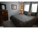 Comfortable bedroom with a decorative bedspread, matching pillows, and a vintage wooden dresser at 410 Mockingbird Dr, Loganville, GA 30052