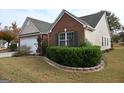 Charming home with a combination of brick and siding, featuring manicured landscaping and a well-maintained lawn at 410 Mockingbird Dr, Loganville, GA 30052