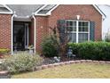 Brick front of home with decorative landscaping, a well-manicured lawn, and an inviting front entrance at 410 Mockingbird Dr, Loganville, GA 30052