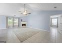Spacious living room with a fireplace, ceiling fan, and ample natural light from the windows at 410 Mockingbird Dr, Loganville, GA 30052