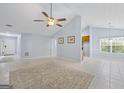 Open-concept living room with tile flooring, ceiling fan, and easy access to kitchen and front door at 410 Mockingbird Dr, Loganville, GA 30052