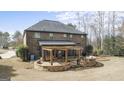 An outdoor entertaining space with a stone patio, seating area, and backyard views at 1110 Eagles Brooke, Locust Grove, GA 30248