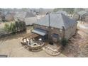 Aerial view of backyard featuring a stone patio, pergola, fire pit, and outdoor living space at 1110 Eagles Brooke, Locust Grove, GA 30248