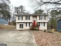 Two-story home featuring a wooden porch, spacious driveway, and colorful red front door at 5743 Rock Rd, Union City, GA 30291