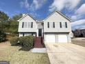Charming two-story home with a well-maintained lawn, attached two-car garage, and inviting front entrance at 1202 Grove Trail Pass, Douglasville, GA 30134