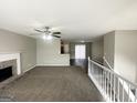 Spacious living room features neutral walls, carpet, a ceiling fan, and a fireplace with a brick hearth at 1202 Grove Trail Pass, Douglasville, GA 30134