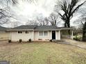Traditional ranch home exterior featuring a neutral color palette and a covered carport area at 2310 Ousley Ct, Decatur, GA 30032
