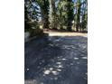 A paved driveway provides ample parking space, surrounded by mature trees and greenery at 1125 Carlo Sw Ct, South Fulton, GA 30331