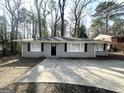 Traditional gray brick home with a modern black front door and matching shutters at 4734 Campbellton Sw Rd, Atlanta, GA 30331