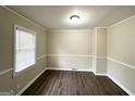 Inviting living room showcasing stylish dark floors, crown molding, and a bright window at 2030 Mark Trl, Decatur, GA 30032