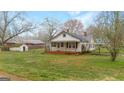 Classic single-story home with a metal roof and covered porch, nestled in a well-maintained lawn at 110 Bevis Cir, Bowdon, GA 30108