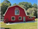 Red barn with white trim, horse accents and green door, situated on a grassy lawn at 225 Banks Rd, Fayetteville, GA 30214