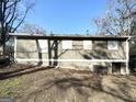 Neutral single-story back exterior with siding, brick foundation and boarded up windows at 411 Argus Nw Cir, Atlanta, GA 30331