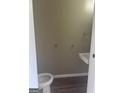 Cozy powder room features a modern sink and toilet, with wood-look laminate flooring at 923 Regal Path Ln, Decatur, GA 30030