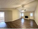 Spacious living room features wood floors, fireplace, ceiling fan, and neutral paint at 246 Bridgewood Se Dr, Conyers, GA 30094