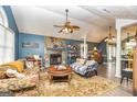 Cozy living room featuring a stone fireplace, ceiling fan, hardwood floors, and comfortable seating at 390 Marsha Way, Sharpsburg, GA 30277