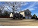 Charming two-story home with brick accents, two-car garage, and dormant lawn in winter at 1022 Gloria Grand Blvd, Mcdonough, GA 30252