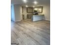 Open-concept living room boasts modern wood look flooring and a view of the kitchen at 4856 Station Ln # 21, Union City, GA 30349
