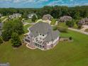 Expansive home with a stone and beige exterior, set on a lush green lawn in a beautiful neighborhood at 550 Wentworth Ct, Fayetteville, GA 30215