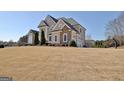 Elegant two-story home featuring a stone and stucco exterior, decorative gables, and a well-manicured lawn at 550 Wentworth Ct, Fayetteville, GA 30215
