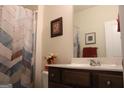 Well-lit bathroom with a wood vanity, framed mirror, and patterned shower curtain at 2297 Knob Creek Dr, Snellville, GA 30078