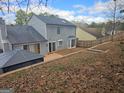 An aerial backyard view of a gray two-story home with a black roof, bay window, and privacy fence at 6558 Eastbriar Dr, Lithonia, GA 30058
