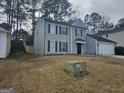 Gray, two-story house with a white garage and green lawn at 6558 Eastbriar Dr, Lithonia, GA 30058
