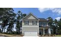 Two-story home with gray siding, dark shutters, and a two-car garage at 140 Tye St, Stockbridge, GA 30281