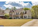 Two-story home with stone accents, an attached garage, a driveway, and a well-maintained lawn at 270 Sturgess Run, Sharpsburg, GA 30277