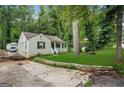 Exterior view of a white home with well-maintained landscaping and a stone retaining wall at 1273 Boulevard Lorraine Sw, Atlanta, GA 30311