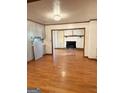 Open dining room with hardwood floors, fireplace, and view into kitchen at 6576 Randall Mark Dr, Morrow, GA 30260