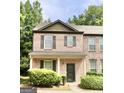 Inviting two-story brick townhome featuring a covered front porch and manicured bushes at 1406 Bayrose Cir # 6B, East Point, GA 30344