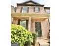 Classic two-story brick townhome with a charming covered porch and front yard shrubs at 1406 Bayrose Cir # 6B, East Point, GA 30344