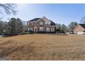 Spacious front yard featuring a brick home with manicured landscaping and mature trees at 123 Stratmore Pl, Stockbridge, GA 30281