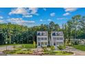 An eye-level aerial view of two luxurious three-story homes surrounded by lush greenery at 930 Laurel Brooke Ave, Peachtree City, GA 30269
