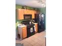 Functional kitchen with black appliances, wooden cabinets, and bright green walls at 11714 Double Lake Xing, Fayetteville, GA 30215