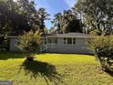 Beautiful home with lush landscaping and a sprawling green lawn perfect for outdoor enjoyment at 47 Elm St, Hampton, GA 30228