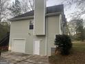 Exterior of house with white garage door, small window, and light green siding at 7810 Capps Ferry Rd, Douglasville, GA 30135