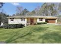 Lovely single-story home with a lush green lawn, complemented by mature trees and shrubs at 415 Southmoor Cir, Stockbridge, GA 30281