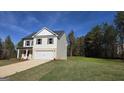 View of two-story home featuring a concrete driveway, two car garage, and a large lawn at 55 Barton Ln, Covington, GA 30016