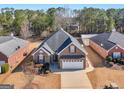An aerial view of a well-maintained home with a manicured lawn, surrounded by lush greenery and neighboring houses at 509 Carleton Pl, Locust Grove, GA 30248