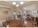 View of the dining room with chandelier and into the living room with fireplace and vaulted ceiling at 509 Carleton Pl, Locust Grove, GA 30248