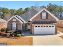 Charming single-Gathering home featuring brick exterior, symmetrical design, and a two-car garage at 509 Carleton Pl, Locust Grove, GA 30248