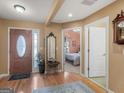 Inviting foyer featuring hardwood floors, neutral walls, decorative mirror, and an exterior door at 509 Carleton Pl, Locust Grove, GA 30248