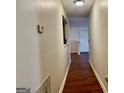 Hallway with dark wood floors leading to a white door at 19201 Waldrop Cv, Decatur, GA 30034