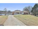 Expansive front exterior showcasing driveway, lakeside access and well-maintained lawn at 205 Castlewood Rd, Tyrone, GA 30290